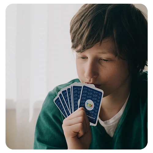 Bimbo che gioca a carte mantenendole con la mano